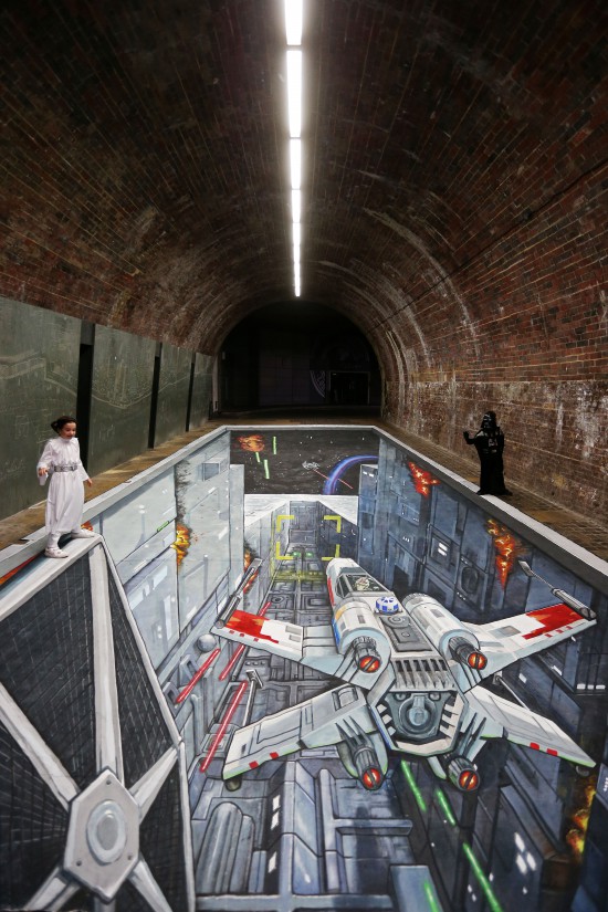 Celebrating the launch of the new Star Wars: Rise Against the Empire Play Set for Disney Infinity 3.0 - fans gathered to pose next to an epic piece of 3D artwork recreating the Death Star Trench Run featured in the game. London commuters today were unexpectedly immersed in an epic piece of 3D artwork underneath Southwark Bridge, to mark the launch of the new Rise Against the Empire Play Set for Disney Infinity 3.0: Play Without Limits. The artwork, created by world-renowned artists 3D Joe and Max, is a re-creation of the iconic Death Star trench run from Star Wars: A New Hope, and is featured in the Rise Against the Empire Play Set out Friday 2nd October, which features iconic moments from the original Star Wars trilogy. It is open to the public from 8am – 8pm on Thurs 1st and Fri 2nd October.